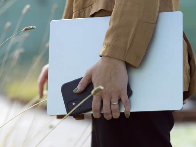 Person holding a computer and an phone.